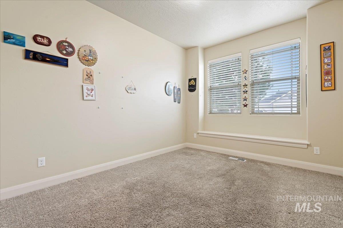 Carpeted spare room with baseboards and a textured ceiling