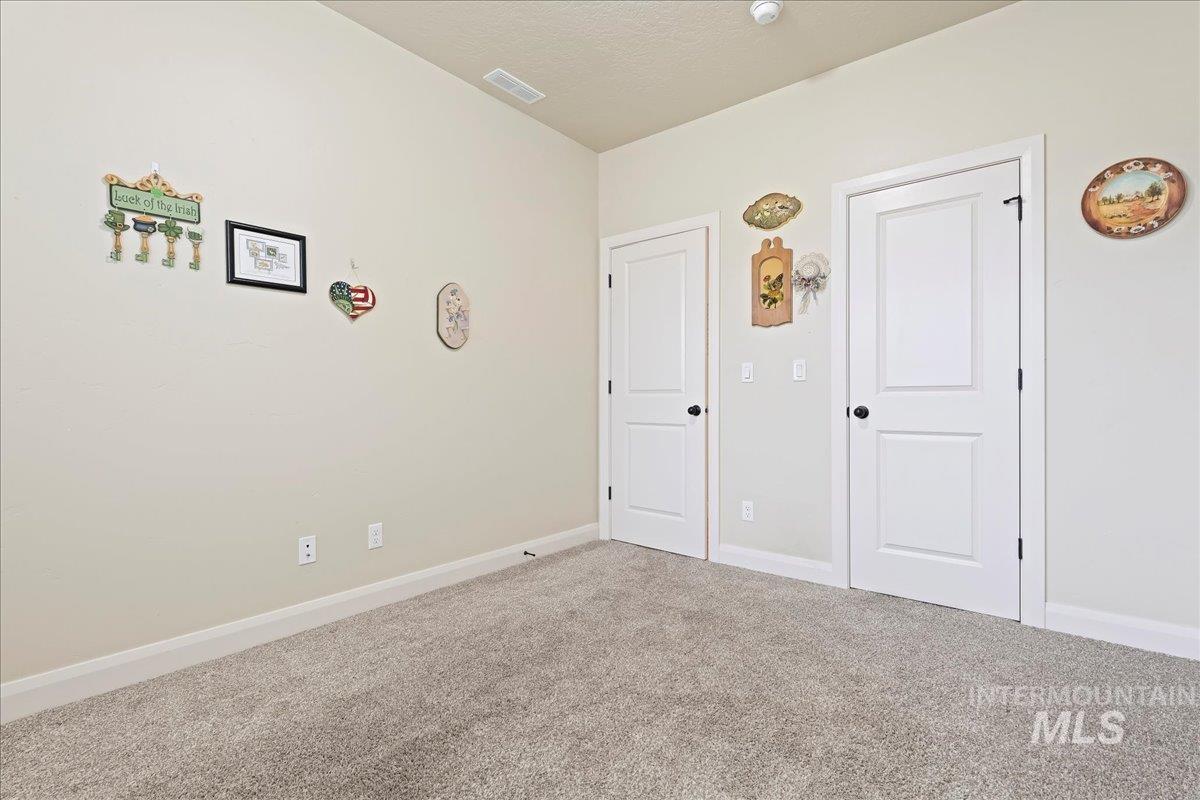 Unfurnished bedroom featuring carpet and baseboards
