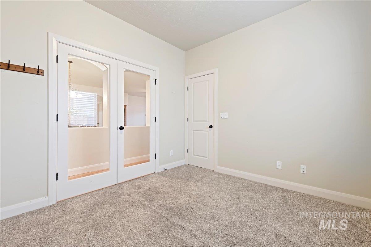 Unfurnished room with french doors and carpet floors