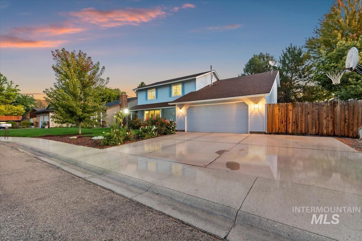 Traditional-style house with driveway, an attached garage, and roof with shingles