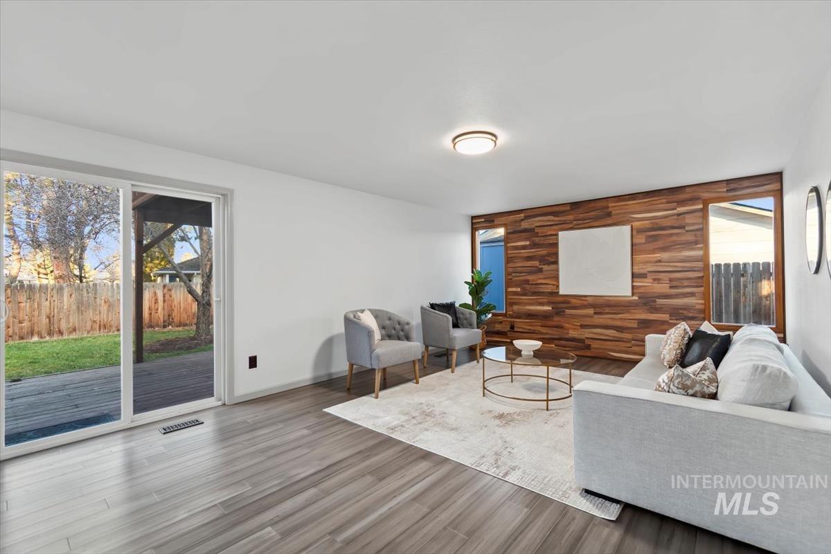 Living room featuring an accent wall, wood walls, and wood finished floors
