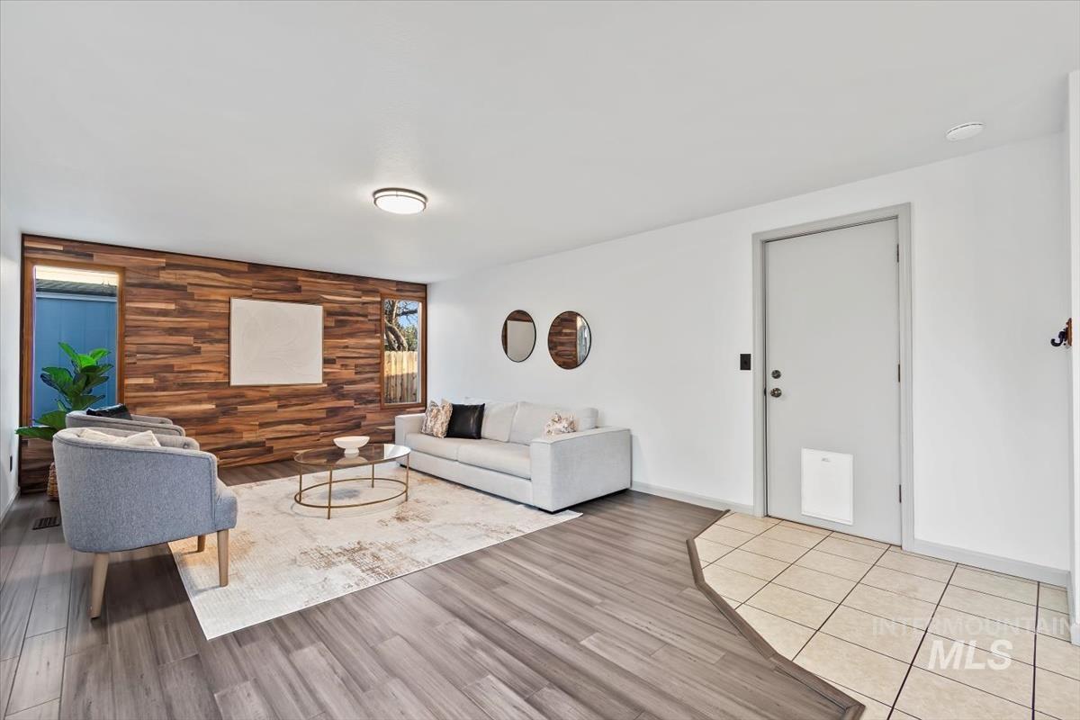 Living room featuring wooden walls, an accent wall, and wood finished floors