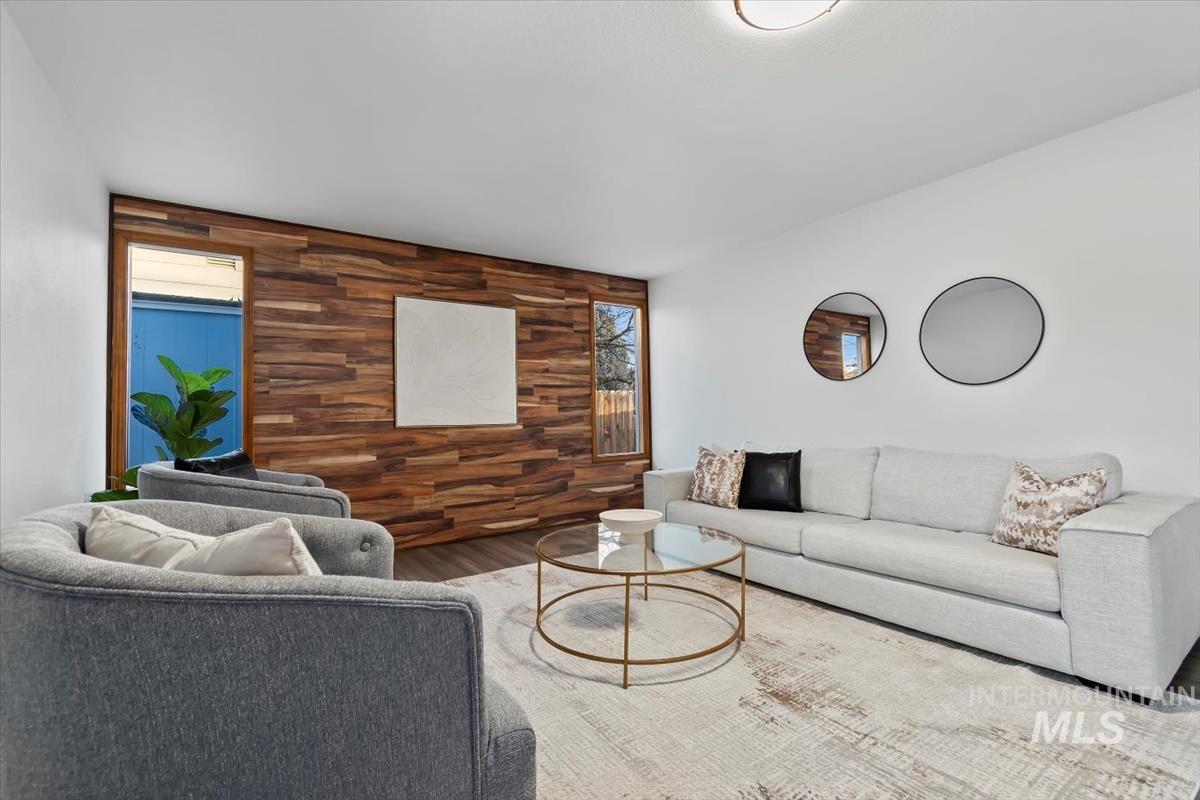 Living area with wooden walls, an accent wall, and wood finished floors
