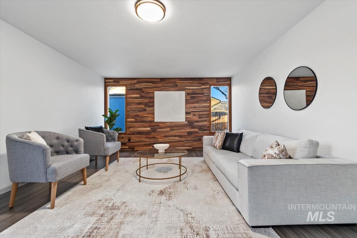 Living room featuring an accent wall, wood walls, and wood finished floors