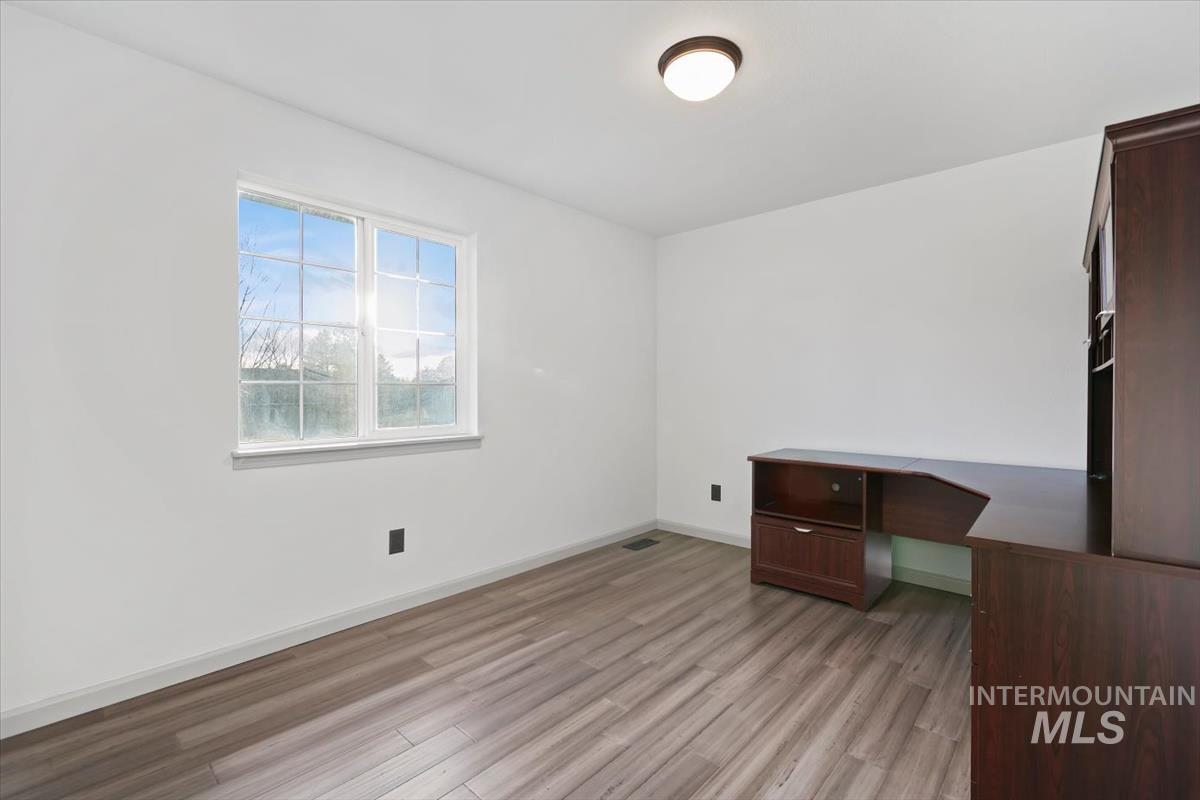 Unfurnished office featuring built in desk and light wood finished floors