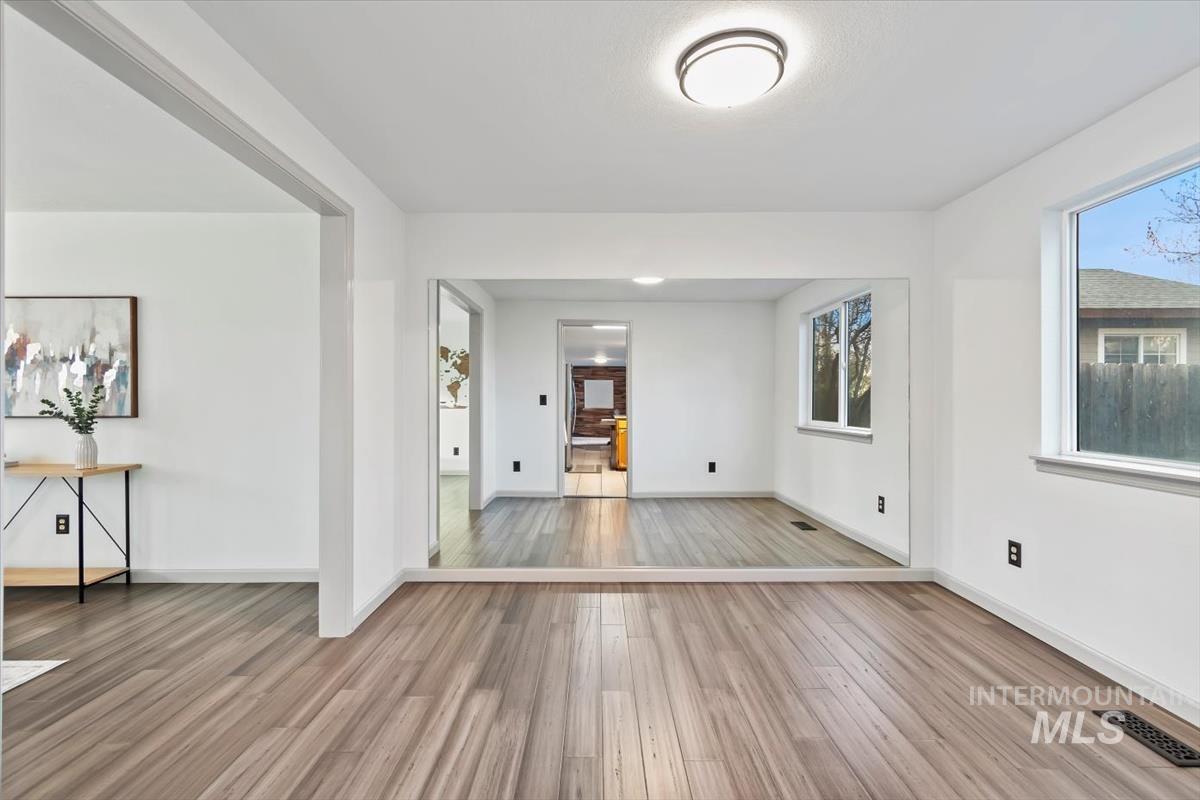 Spare room featuring light wood-type flooring and baseboards