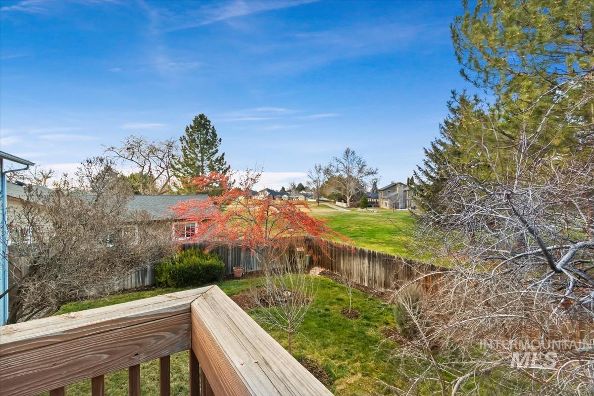 Fenced backyard featuring a balcony and a residential view