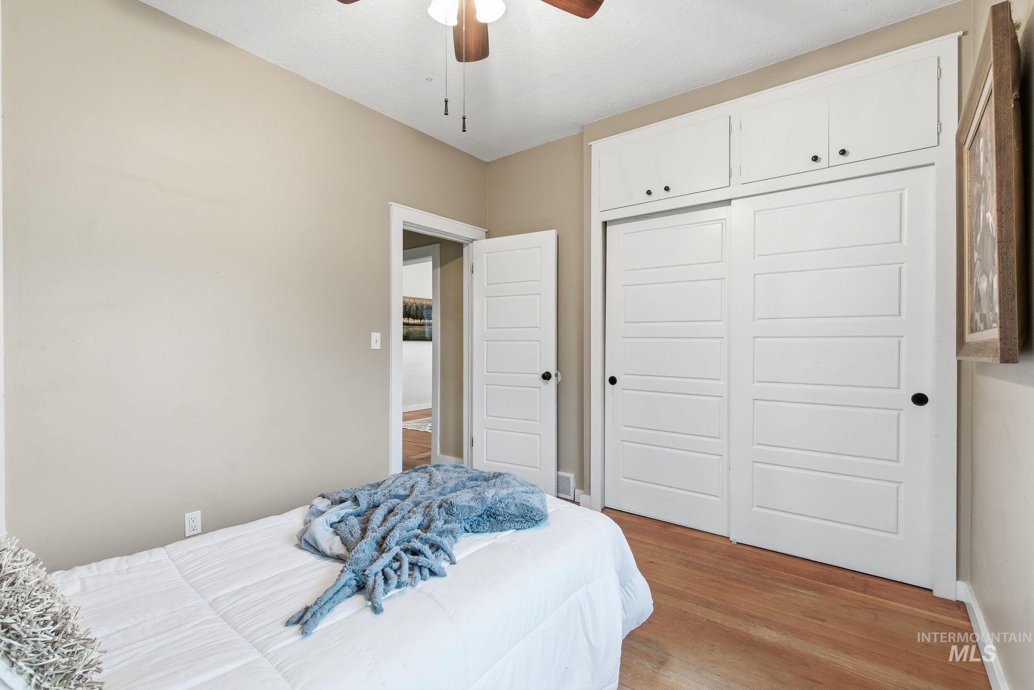 Bedroom with light wood-style flooring, a closet, and ceiling fan