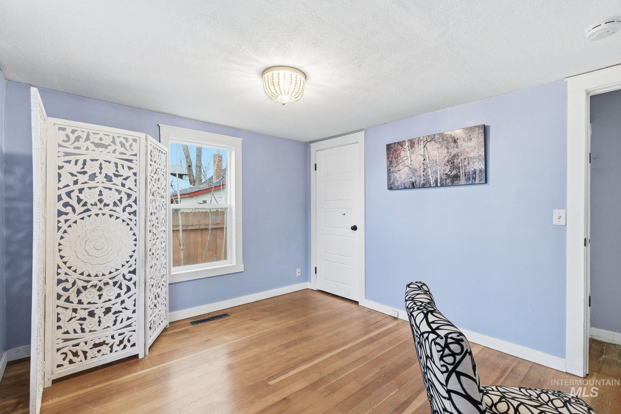 Unfurnished bedroom with light wood-style flooring and a textured ceiling