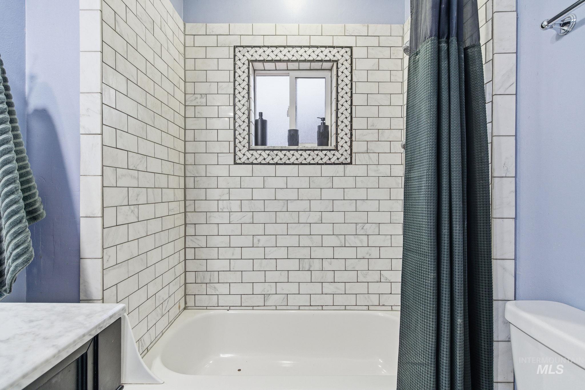 Bathroom with shower / tub combo with curtain and vanity