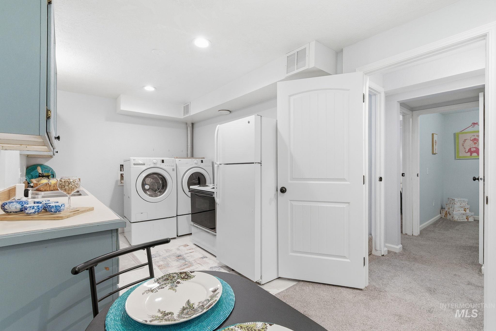 Laundry room with independent washer and dryer, light colored carpet, and recessed lighting