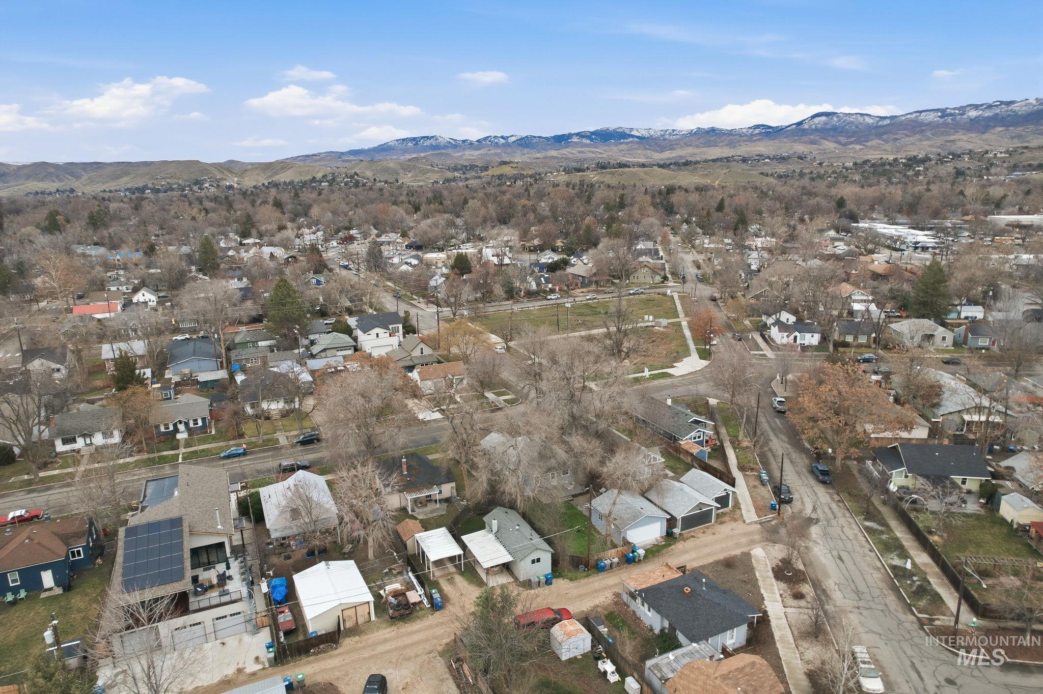 Aerial overview of property's location featuring nearby suburban area and a mountain backdrop