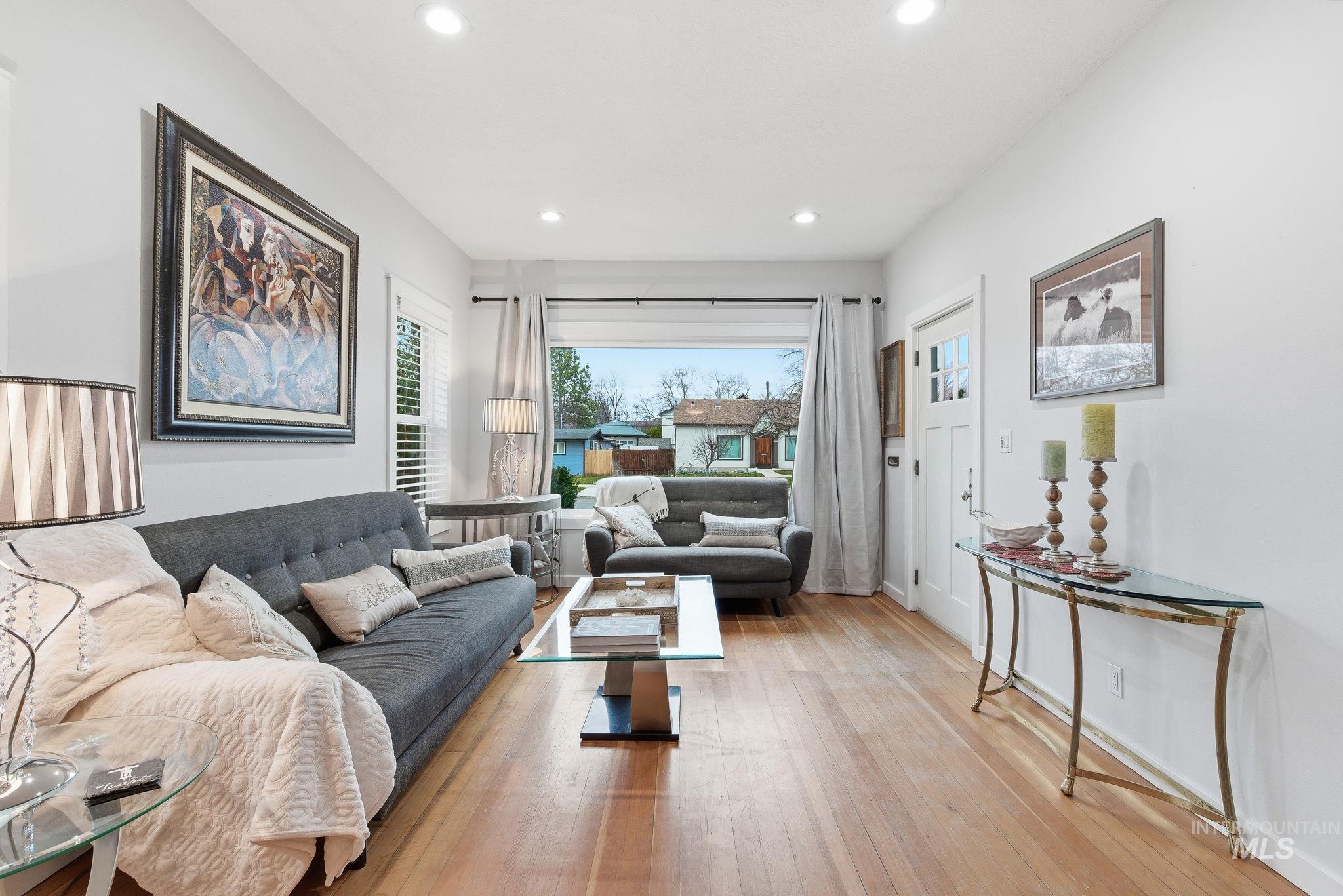 Living room with light wood-type flooring and recessed lighting
