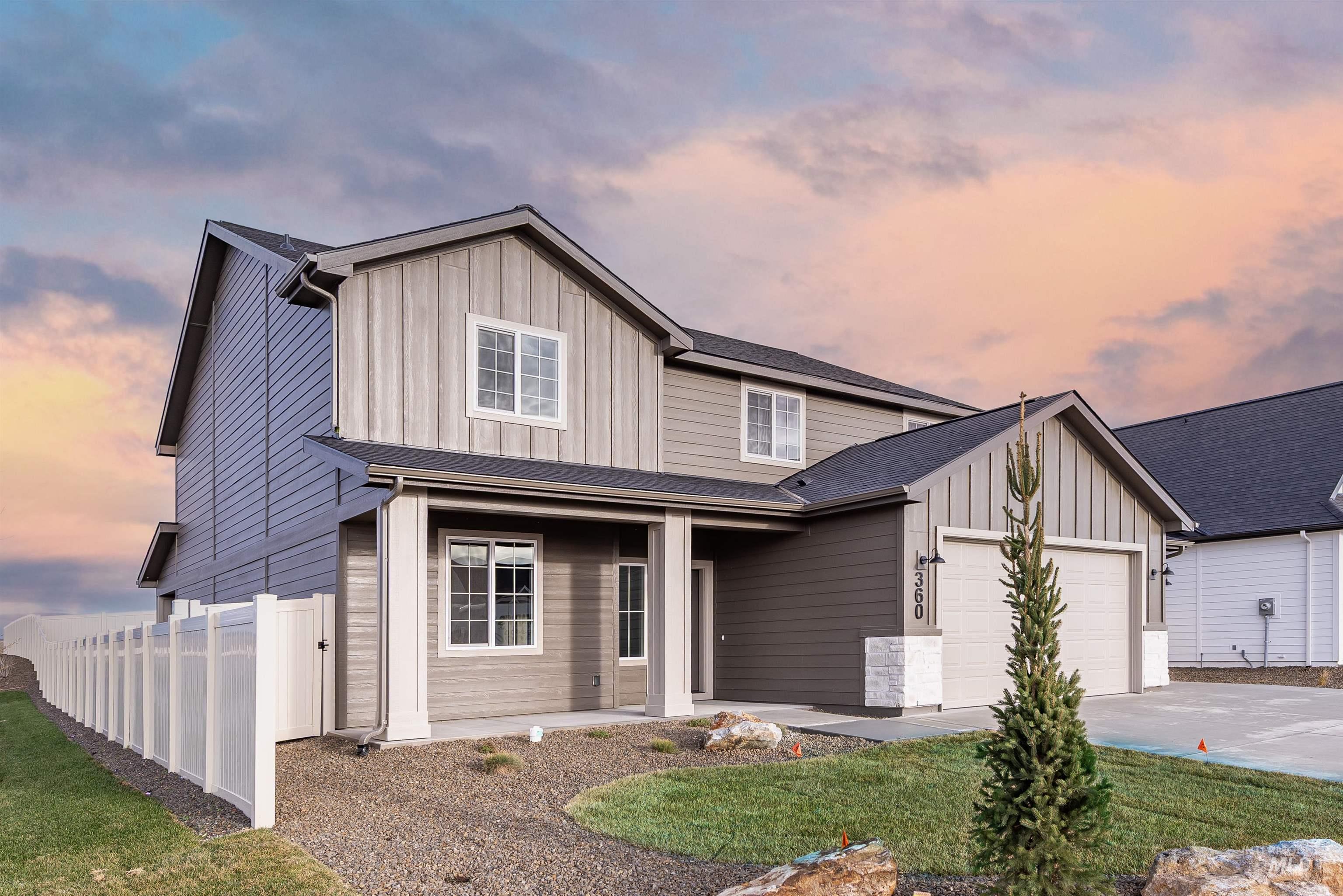 Modern farmhouse style home featuring board and batten siding, driveway, covered porch, and an attached garage
