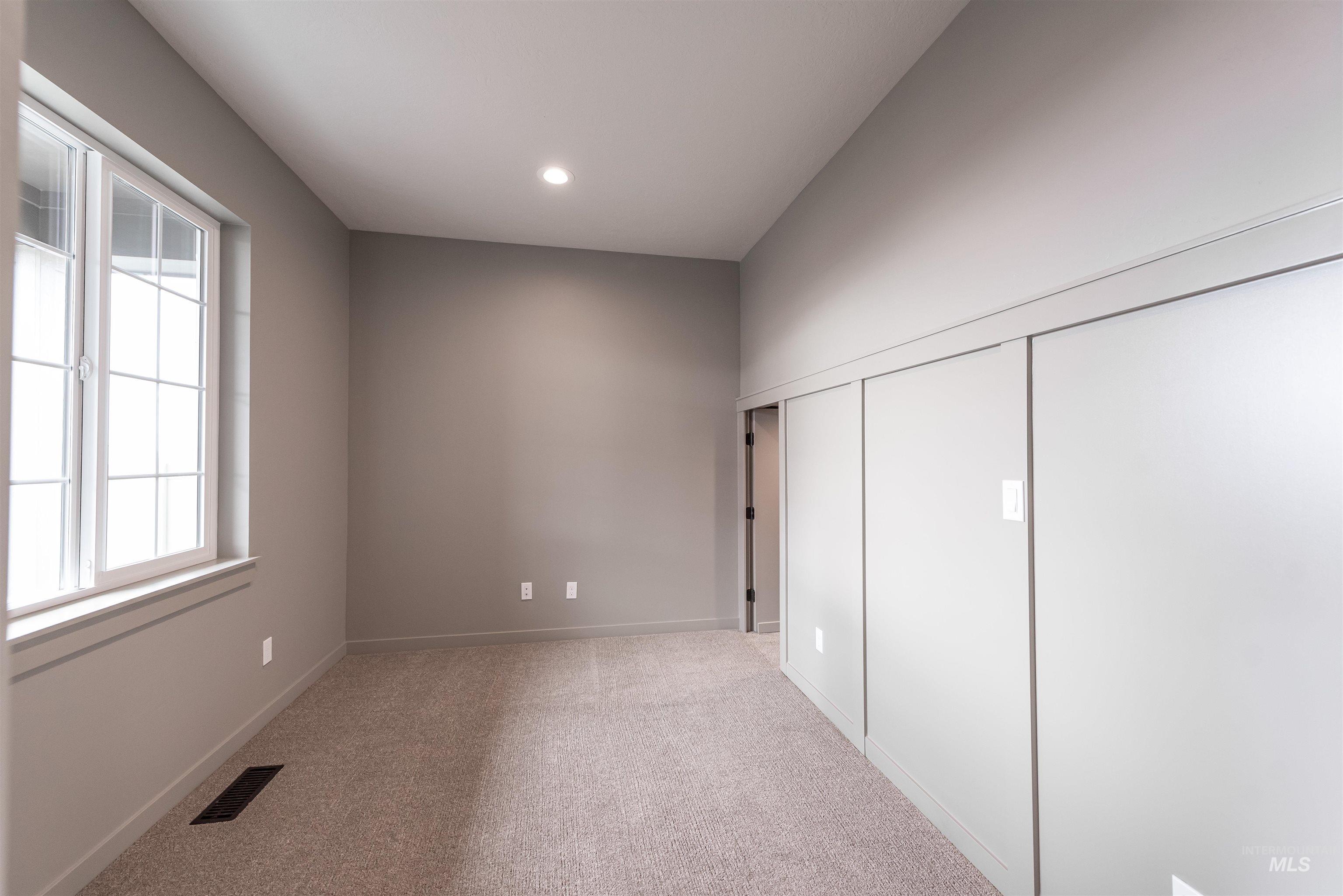 Unfurnished bedroom with light colored carpet, a closet, and recessed lighting
