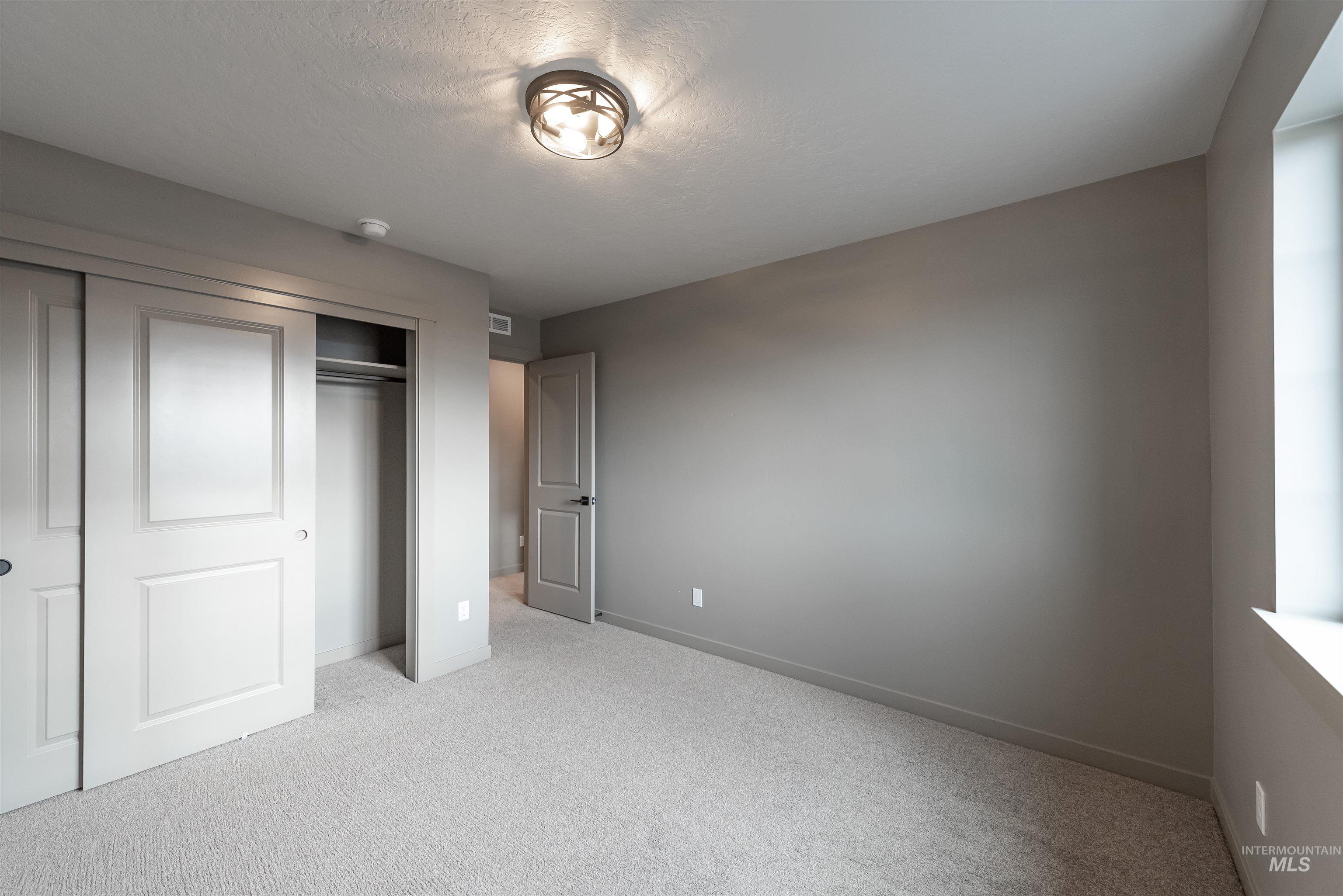 Unfurnished bedroom featuring light colored carpet and a closet