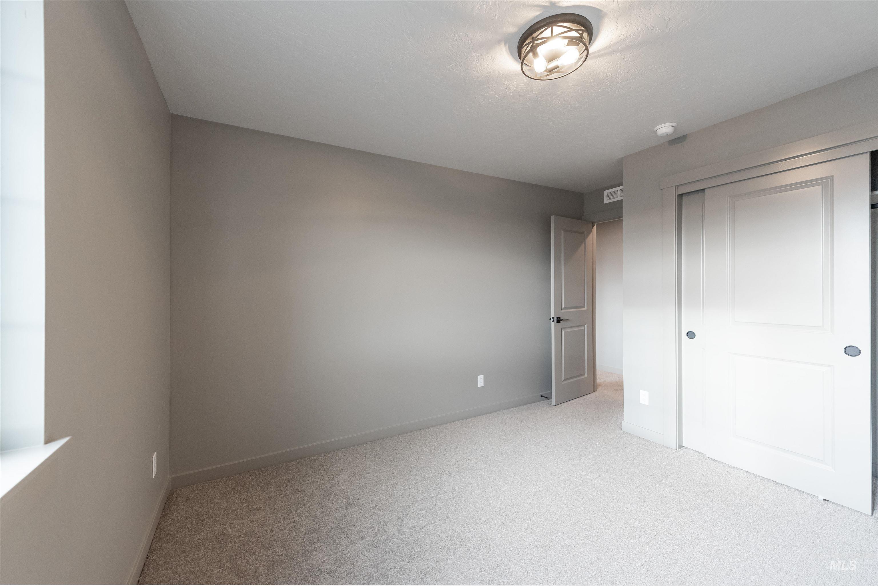 Unfurnished bedroom with light colored carpet and a closet