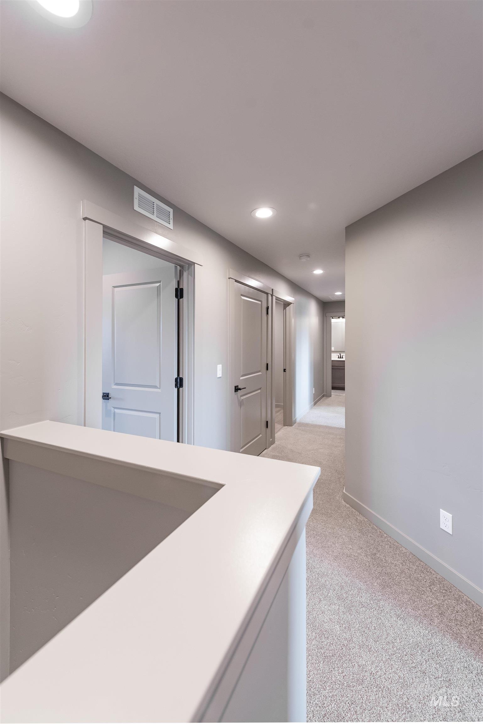 Hallway with recessed lighting, light carpet, and a barn door
