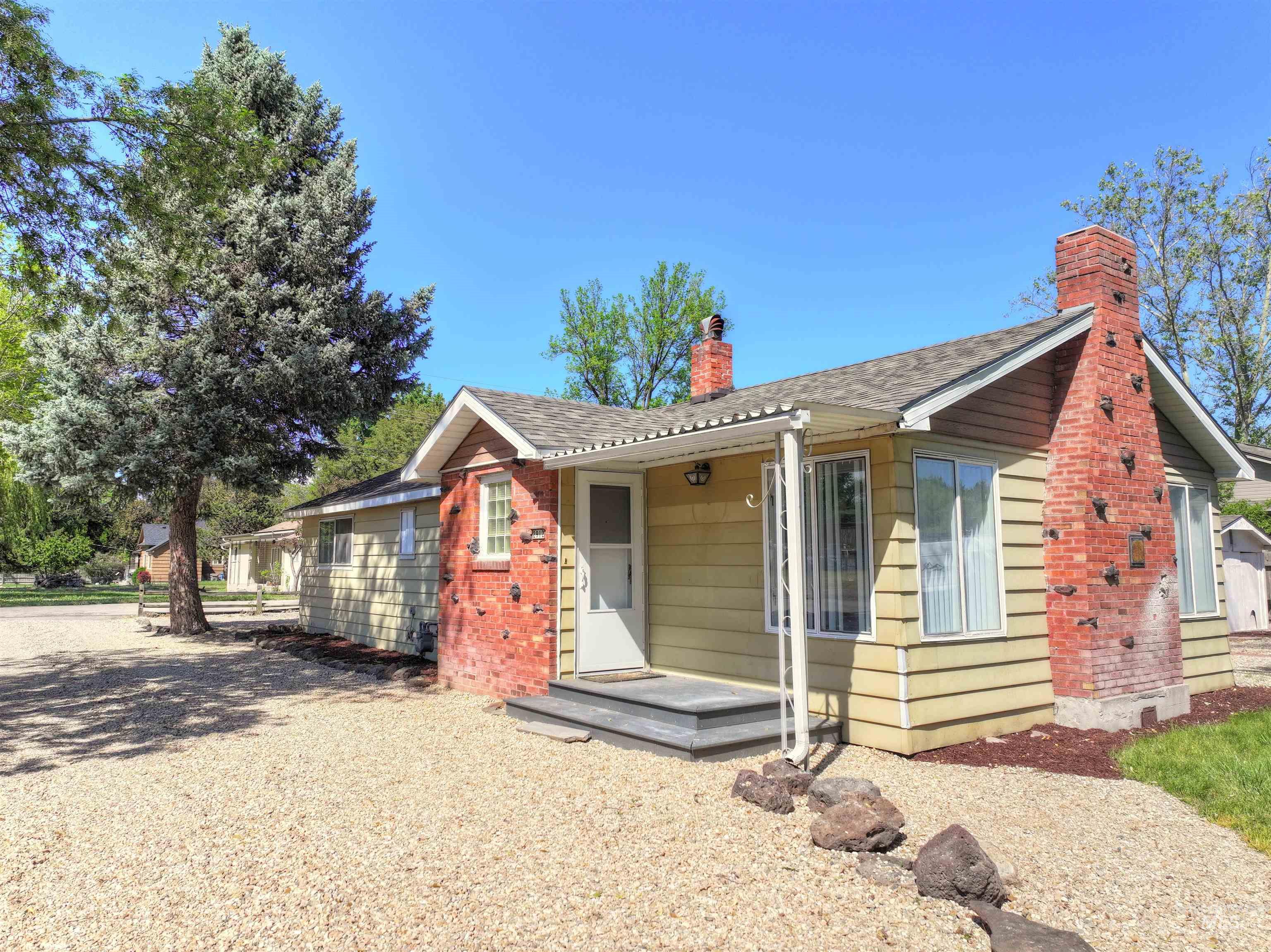 View of front of house featuring a chimney and roof with shingles