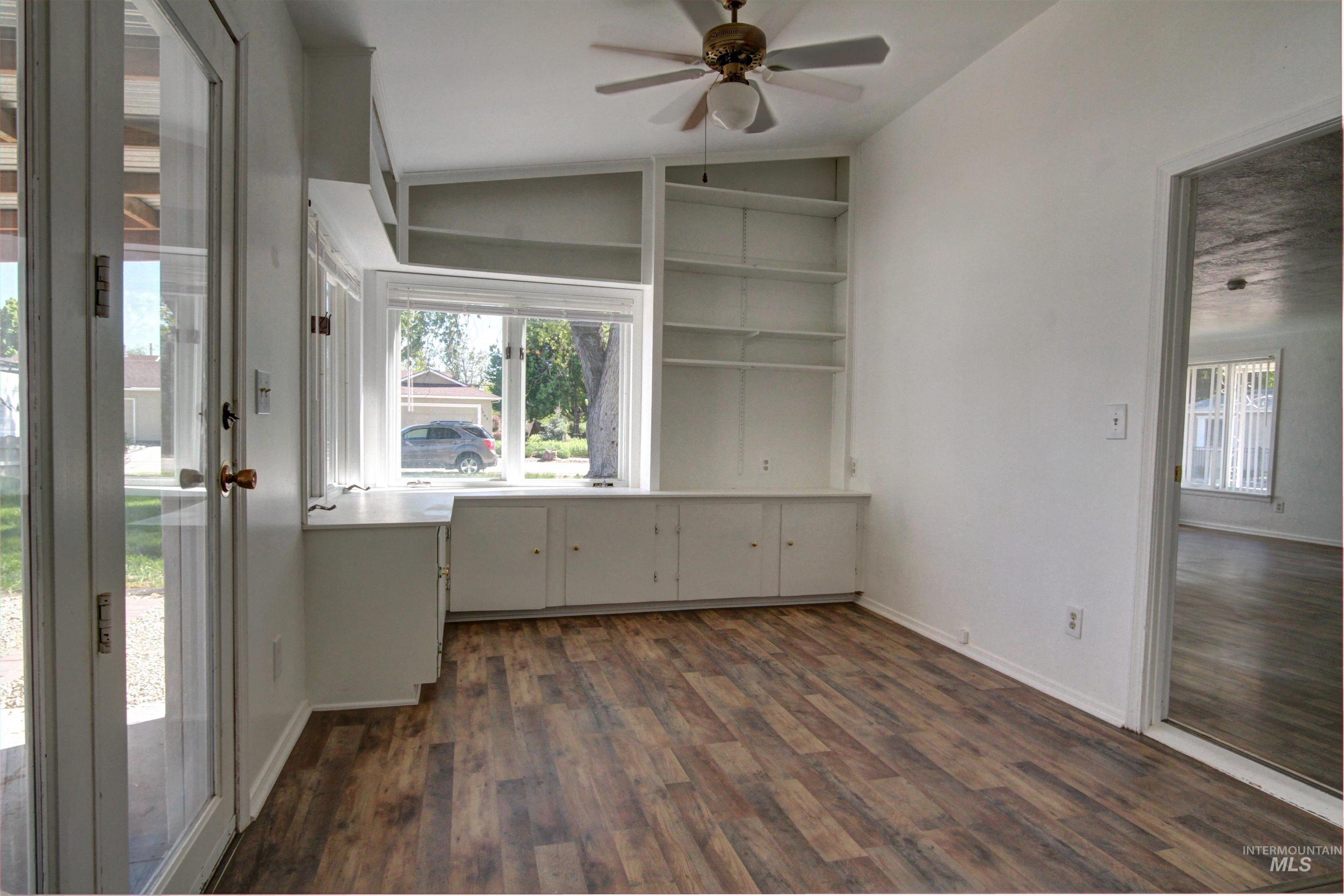 Unfurnished office with plenty of natural light, lofted ceiling, a ceiling fan, and dark wood-style floors