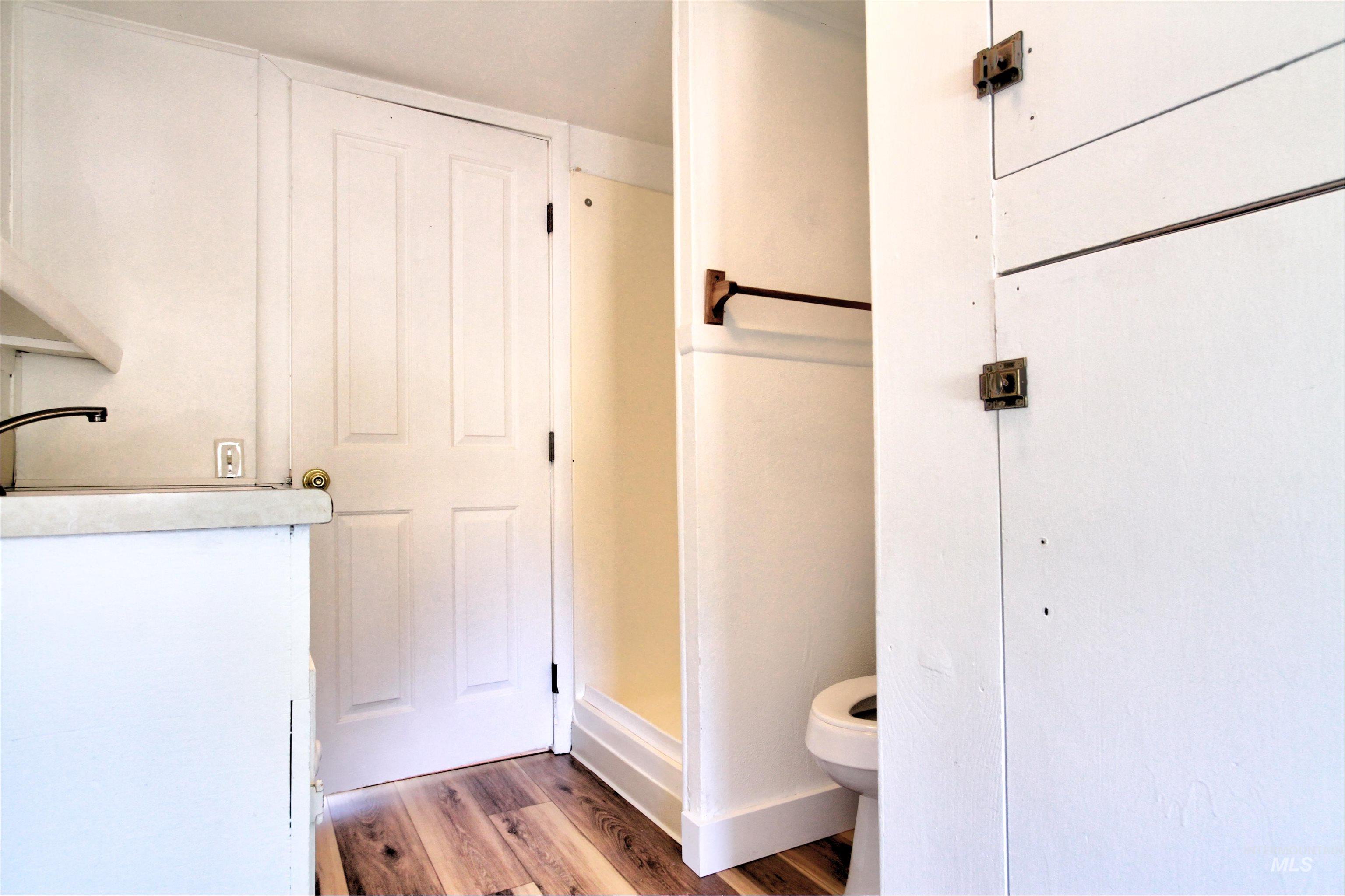 Bathroom featuring dark wood-style floors and a stall shower