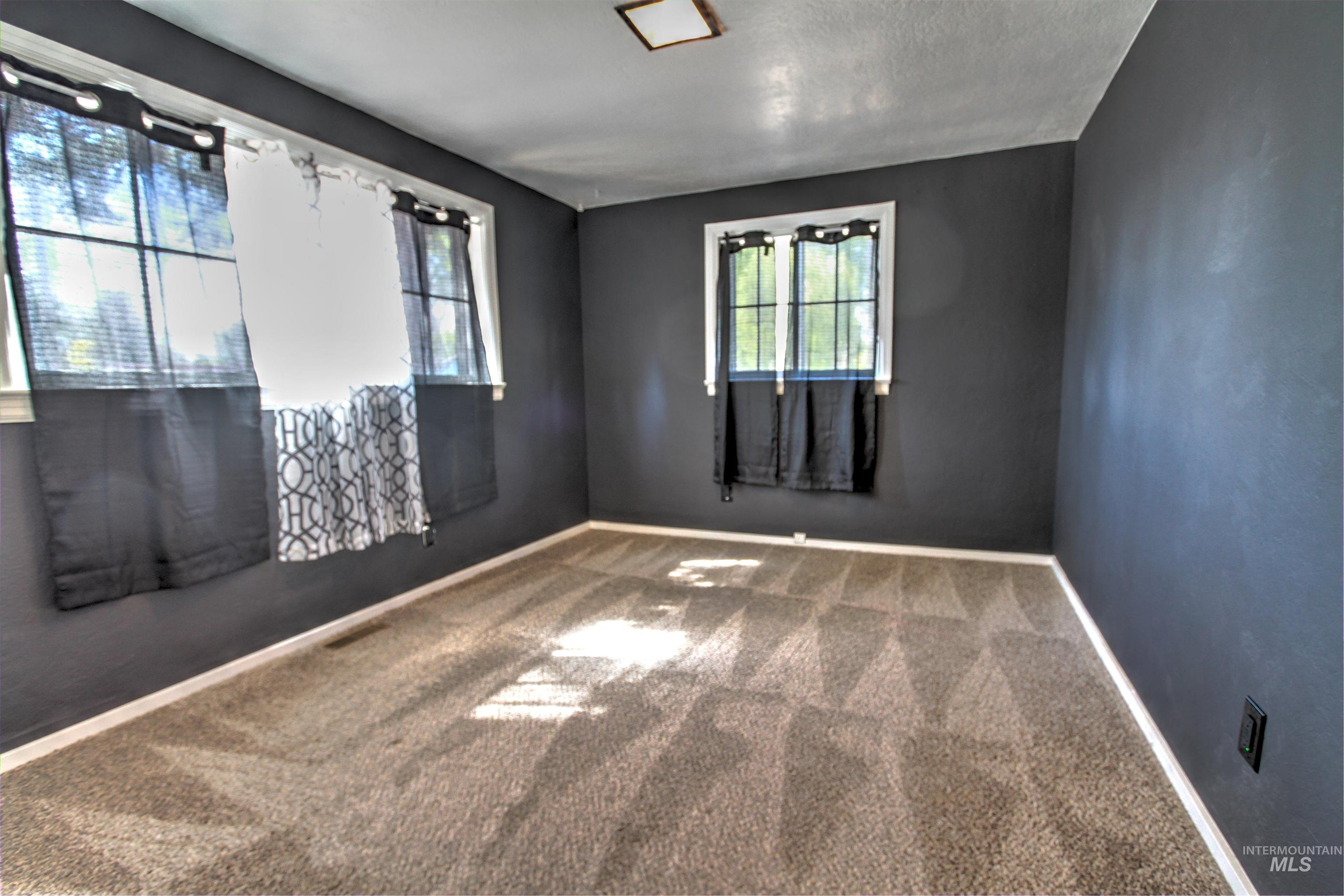 Empty room with carpet flooring and healthy amount of natural light