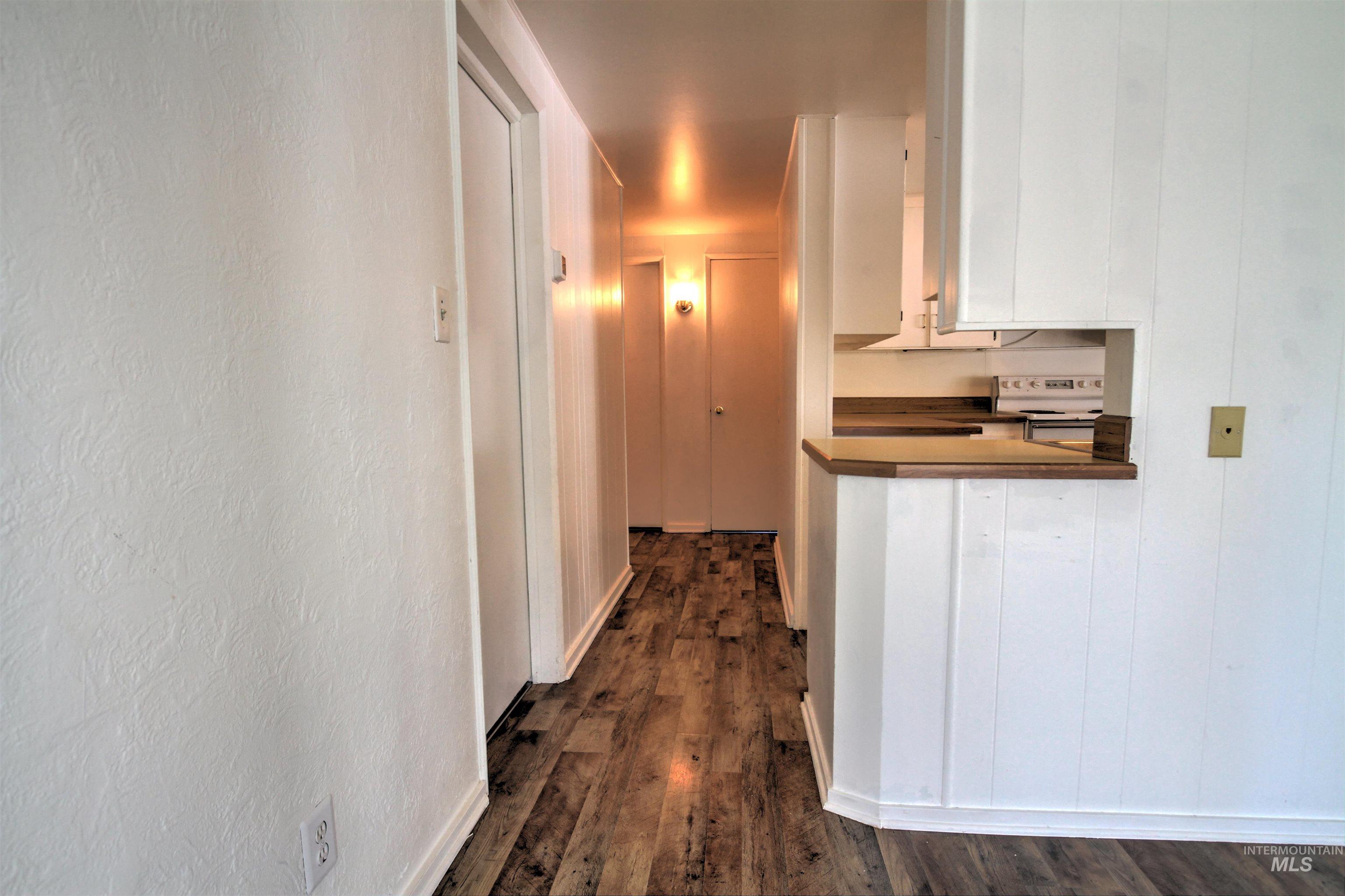 Corridor featuring dark wood-style flooring